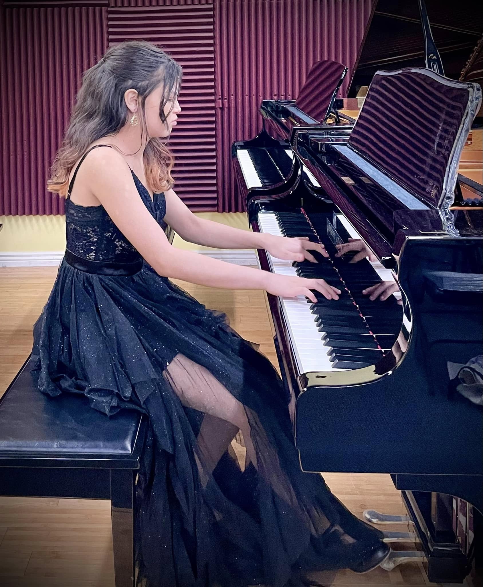 A senior piano student performing at a grand piano in 2024